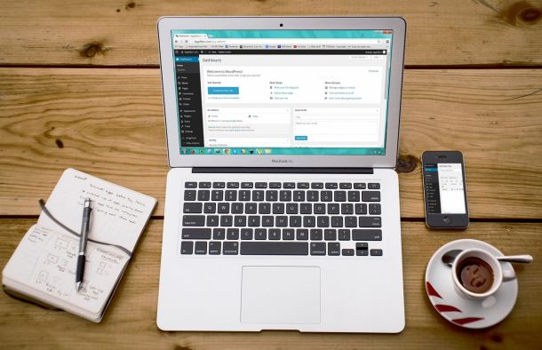 Ordinateur portable, smartphone et café posés sur un bureau de travail