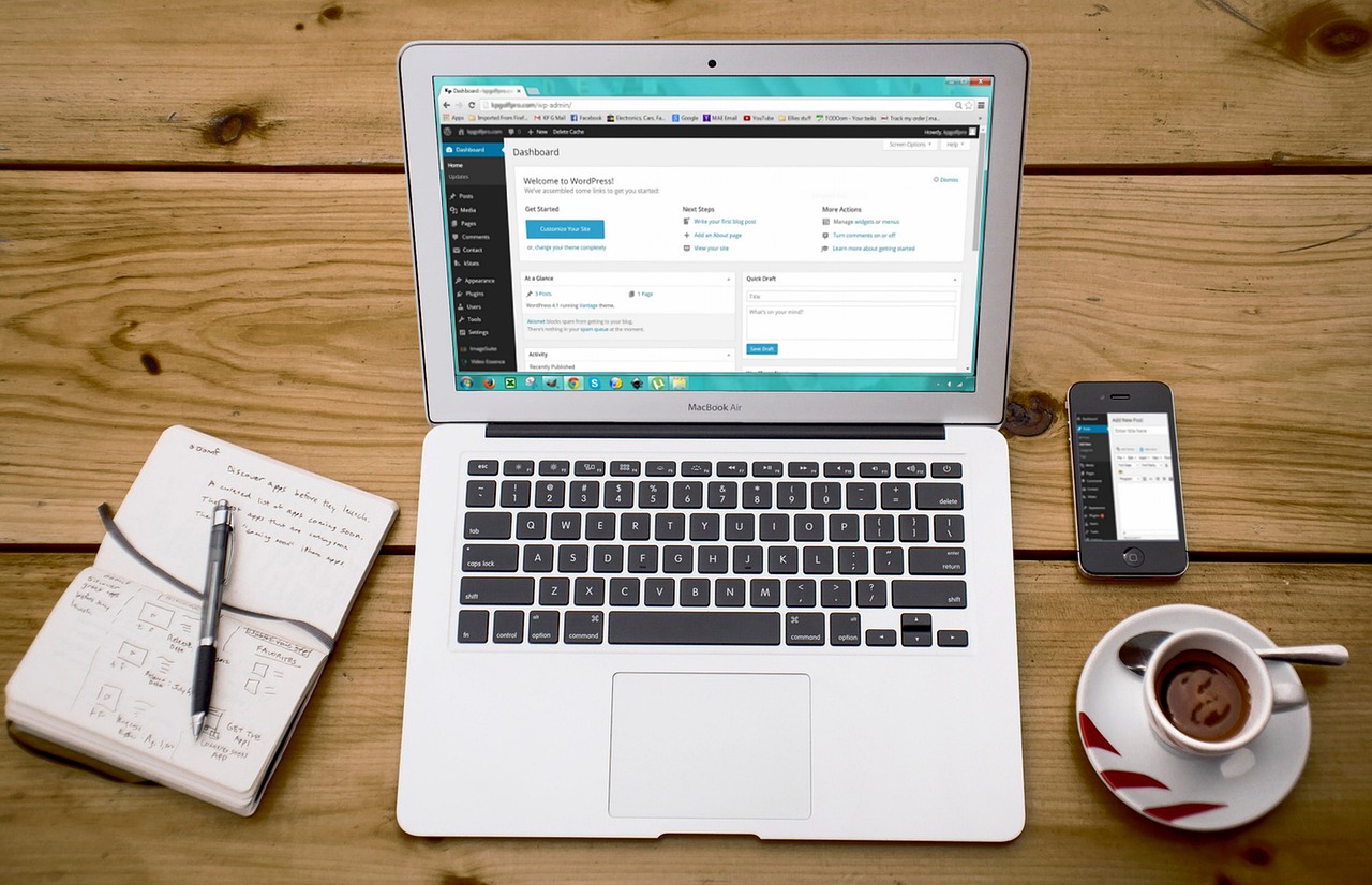 Ordinateur portable, smartphone et café posés sur un bureau de travail
